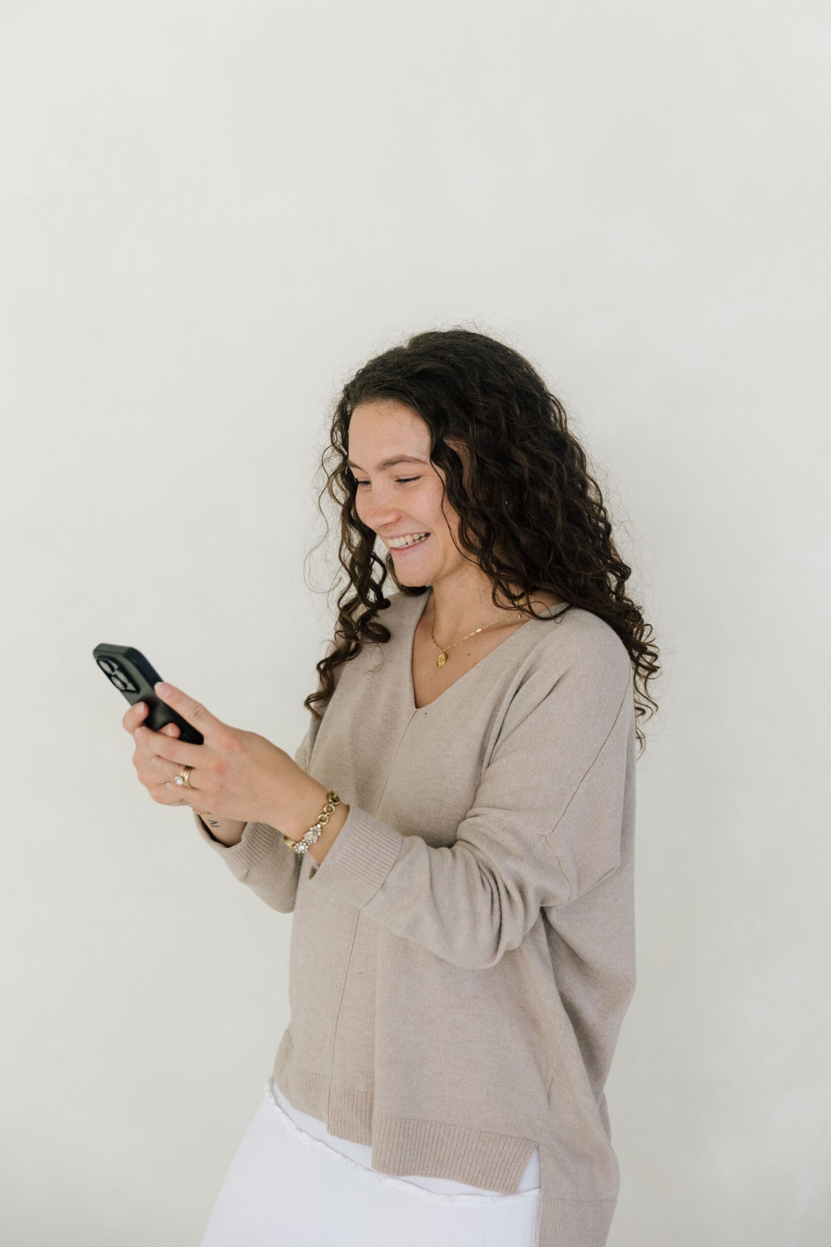 Girl holding phone smiling looking at Instagram growth ideas